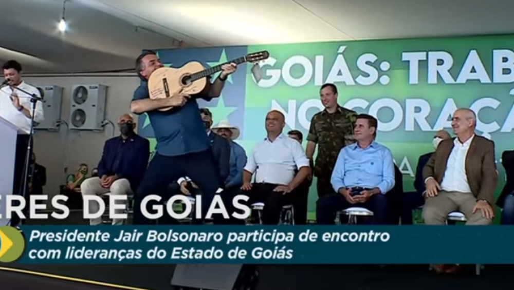 Em Goiânia, Bolsonaro é presenteado com violão autografado por sertanejos e faz gesto de arma