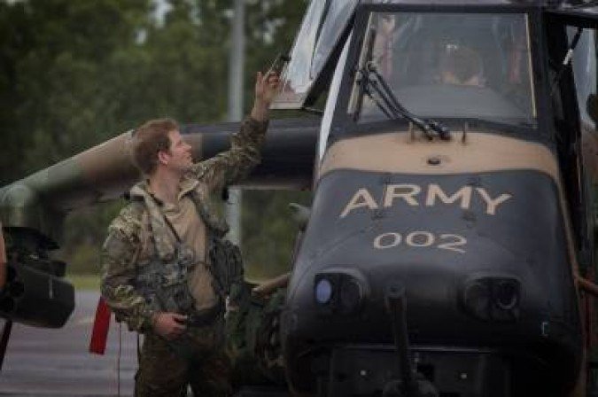 In this undated handout photograph received on April 18, 2015, from the Australian Defence department, Britain's Prince Harry prepares a 1st Aviation Regiment Armed Reconnaissance Helicopter (ARH) Tiger for flight at Robertson Barracks in Darwin in Australia's Northern Territory.  Prince Harry completes the first two weeks of a stint with the Australian Army on April 19, 2015, training in bush survival skills, spending time on helicopter duties and playing wheelchair Aussie Rules Football.   AFP PHOTO/HO/AUSTRALIAN DEFENCE/CPL OLIVER CARTER    ----EDITORS NOTE ----RESTRICTED TO EDITORIAL USE MANDATORY CREDIT 