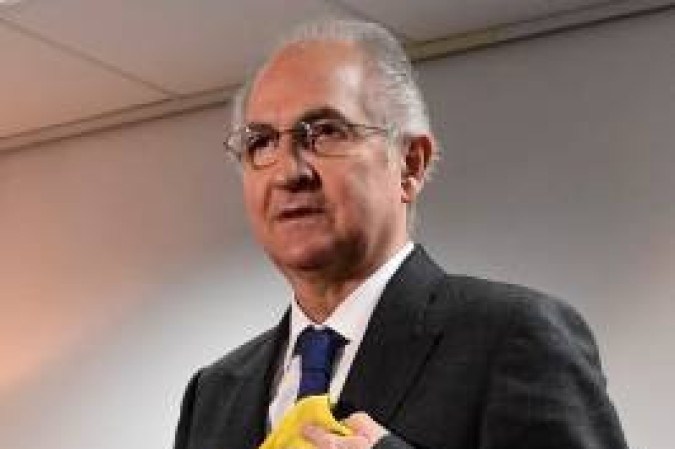 Antonio Ledezma segura a bandeira venezuelana após desembarcar em Madrid em 2017, onde mora com a família