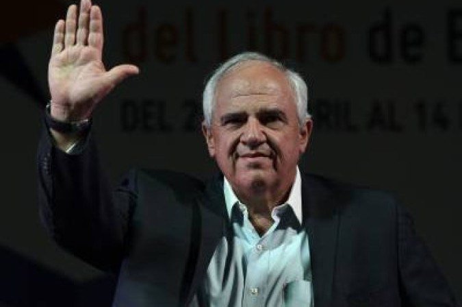 Colombian former President Ernesto Samper waves before the presentation of the book 