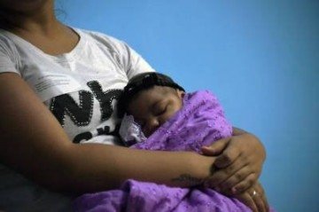 (FILES) In this file photo taken on January 2, 2017 Brenda Pereira, 23 holds her four-month-old baby Maria Fernanda as they wait for medical exams at the State Brain Institute (IEC) in Rio de Janeiro, Brazil.  Brenda was infected with the zika virus, transmitted by the Aedes aegypti mosquito, while pregnant and her daughter was born with microcephaly, during a 2015-2016 wave of babies born with that condition, which involves a smaller-than-normal head size. About one in seven babies who were exposed to the Zika virus in the womb have at least one developmental defect a year later, said a US study on August 7, 2018.The rate of abnormalities -- about 14 percent -- represents more than 30 times the level expected in infants that were not exposed to the mosquito-borne virus, officials with the US Centers for Disease Control and Prevention said. / AFP / VANDERLEI ALMEIDA -  (crédito: VANDERLEI ALMEIDA)