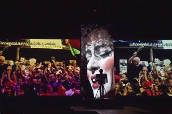 A screen displays an image of the release of Brazil's former President Luiz Inacio Lula da Silva during a performance of 