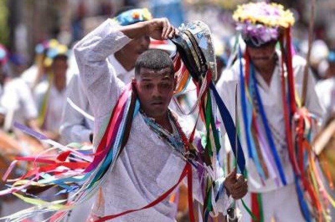 Revellers participate in the traditional festival of the Reinado of Our Lady of the Rosary, St. Efigenia and St. Benedict, through the historic streets of Ouro Preto, Brazil, on January 12, 2020. Through singing, dancing and drumming, the festival honours Chico Rei, a slave brought from Africa who bought his freedom and that of other slaves to become part of the Brazilian folklore. / AFP / DOUGLAS MAGNO - (crédito: DOUGLAS MAGNO) Revellers participate in the traditional festival of the Reinado of Our Lady of the Rosary, St. Efigenia and St. Benedict, through the historic streets of Ouro Preto, Brazil, on January 12, 2020. Through singing, dancing and drumming, the festival honours Chico Rei, a slave brought from Africa who bought his freedom and that of other slaves to become part of the Brazilian folklore. / AFP / DOUGLAS MAGNO - (crédito: DOUGLAS MAGNO)