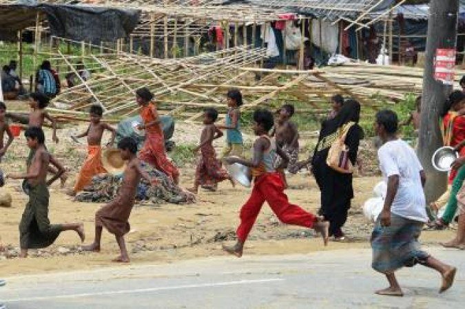 (FILES) In this file photograph taken on September 27, 2017, Rohingya refugees run for food being distributed at the Thangkhali refugee camp near Ukhia. Nearly one in nine people in the world are going hungry, with the coronavirus pandemic exacerbating already worsening trends this year, according to a United Nations report published on July 13, 2020. Economic slowdowns and climate-related shocks are pushing more people into  hunger, while nutritious foods remain too expensive for many, the report found.  / AFP / DOMINIQUE FAGET