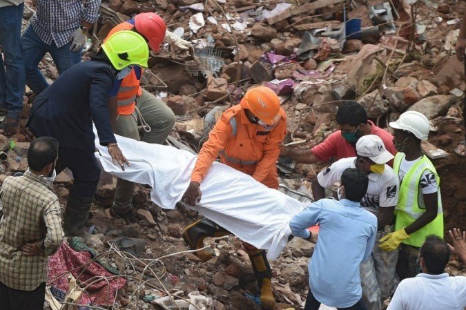 Equipes de resgate carregam o corpo de uma vítima que morreu depois que um prédio de cinco andares desabou em Mahad em 25 de agosto de 2020. - (foto: Punit PARANJPE / AFP) Equipes de resgate carregam o corpo de uma vítima que morreu depois que um prédio de cinco andares desabou em Mahad em 25 de agosto de 2020. - (foto: Punit PARANJPE / AFP)