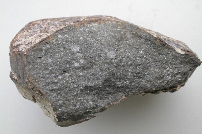 Um pedaço do meteorito Sahara 97096 (cerca de 10 cm de comprimento), um condrito enstatita que contém cerca de 0,5 por cento em peso de água. -  (crédito: Laurett PIANI, Christine FIENI / Muséum national d'Histoire naturelle / AFP)