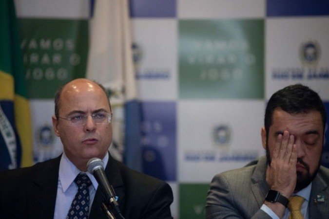 À esquerda, o governador afastado, Wilson Witzel. Ao seu lado, o governador em exercício, Cláudio Castro - (foto: AFP / MAURO PIMENTEL) À esquerda, o governador afastado, Wilson Witzel. Ao seu lado, o governador em exercício, Cláudio Castro - (foto: AFP / MAURO PIMENTEL)