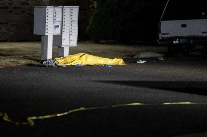 Os investigadores trabalham perto de uma lona que cobre o corpo de um homem que supostamente é Michael Forest Reinoehl depois de ter sido baleado e morto por policiais. - (foto: Nathan Howard / Getty Images / AFP) Os investigadores trabalham perto de uma lona que cobre o corpo de um homem que supostamente é Michael Forest Reinoehl depois de ter sido baleado e morto por policiais. - (foto: Nathan Howard / Getty Images / AFP)