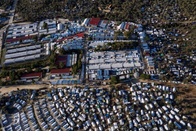 Esta foto de arquivo tirada em 1º de dezembro de 2019 mostra uma vista aérea do campo de refugiados oficial de Moria e do campo improvisado ao redor dele, na ilha grega de Lesbos, no mar Egeu. - (foto: ARIS MESSINIS / AFP) Esta foto de arquivo tirada em 1º de dezembro de 2019 mostra uma vista aérea do campo de refugiados oficial de Moria e do campo improvisado ao redor dele, na ilha grega de Lesbos, no mar Egeu. - (foto: ARIS MESSINIS / AFP)