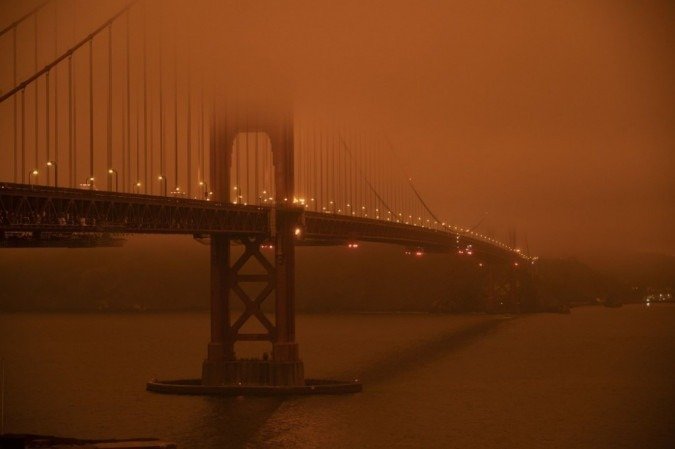 Carros circulam pela Golden Gate Bridge sob um céu cheio de fumaça laranja ao meio-dia em San Francisco, Califórnia, em 9 de setembro de 2020. - (foto: Harold POSTIC / AFP) Carros circulam pela Golden Gate Bridge sob um céu cheio de fumaça laranja ao meio-dia em San Francisco, Califórnia, em 9 de setembro de 2020. - (foto: Harold POSTIC / AFP)