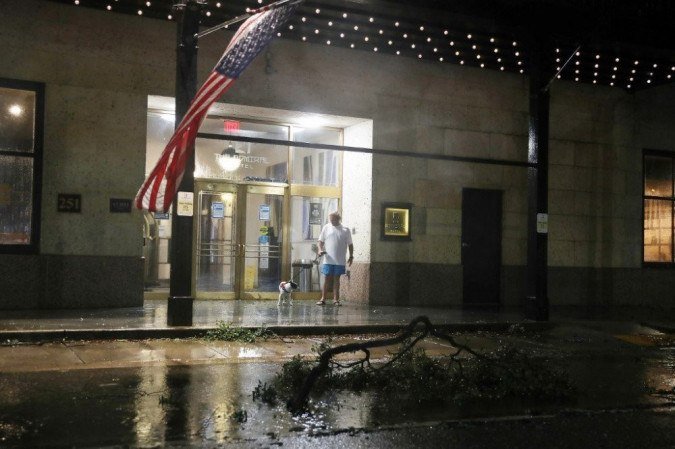 Cabin Hollyhand e seu cachorro Penny olham da entrada do Admiral Hotel Mobile Curio enquanto os ventos e a chuva do furacão Sally passam em 16 de setembro de 2020 em Mobile, Alabama. - (crédito: Joe Raedle / Getty Images / AFP) Cabin Hollyhand e seu cachorro Penny olham da entrada do Admiral Hotel Mobile Curio enquanto os ventos e a chuva do furacão Sally passam em 16 de setembro de 2020 em Mobile, Alabama. - (crédito: Joe Raedle / Getty Images / AFP)