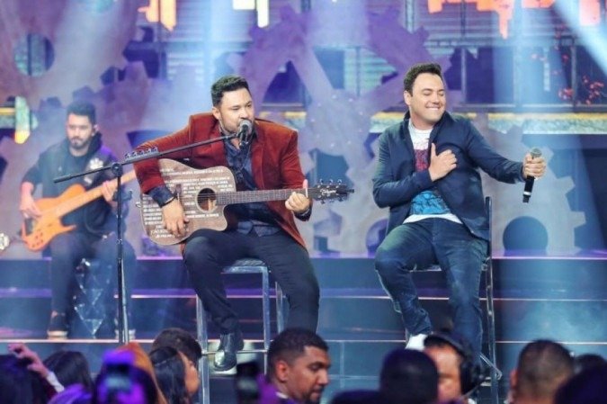 João Bosco (vermelho) e Vinícius (azul) na gravação do DVD 'Ao Vivo em Goiânia' - (crédito: Rubens Cerqueira/Divulgação) João Bosco (vermelho) e Vinícius (azul) na gravação do DVD 'Ao Vivo em Goiânia' - (crédito: Rubens Cerqueira/Divulgação)