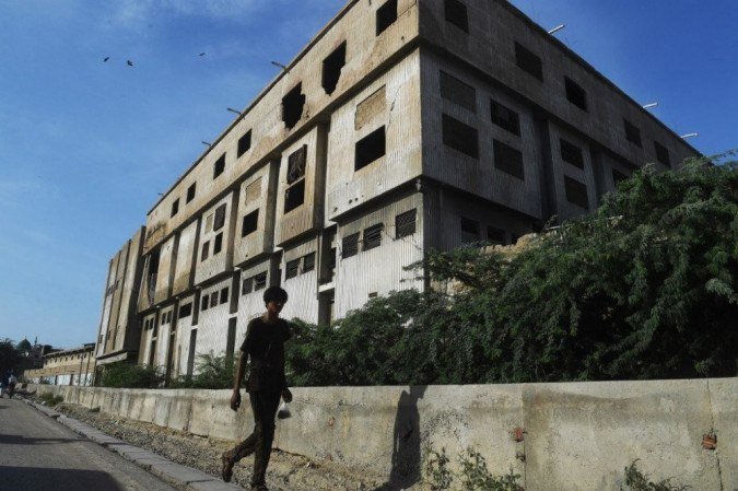 Um homem passa por nós na fábrica de roupas incendiada da Ali Enterprises, onde pelo menos 260 pessoas morreram em 2012. - (crédito: Asif HASSAN / AFP) Um homem passa por nós na fábrica de roupas incendiada da Ali Enterprises, onde pelo menos 260 pessoas morreram em 2012. - (crédito: Asif HASSAN / AFP)