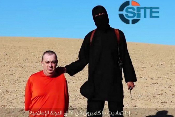 Uma imagem obtida de um vídeo divulgado pelo Estado Islâmico (EI) e identificado pelo monitor privado de terrorismo SITE Intelligence Group em 13 de setembro de 2014 supostamente mostra um militante mascarado (D) ameaçando executar o refém britânico Alan Henning vestido de laranja. - (crédito: AFP PHOTO / HO / SITE INTELLIGENCE GROUP) Uma imagem obtida de um vídeo divulgado pelo Estado Islâmico (EI) e identificado pelo monitor privado de terrorismo SITE Intelligence Group em 13 de setembro de 2014 supostamente mostra um militante mascarado (D) ameaçando executar o refém britânico Alan Henning vestido de laranja. - (crédito: AFP PHOTO / HO / SITE INTELLIGENCE GROUP)