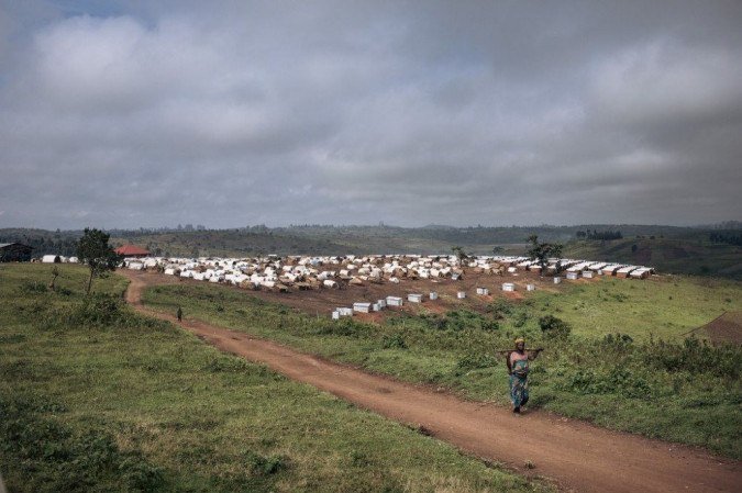 Uma mulher caminha perto do campo Loda IDP, perto de Fataki, na província de Ituri, uma região rica em ouro, nordeste da República Democrática do Congo. - (crédito: ALEXIS HUGUET / AFP) Uma mulher caminha perto do campo Loda IDP, perto de Fataki, na província de Ituri, uma região rica em ouro, nordeste da República Democrática do Congo. - (crédito: ALEXIS HUGUET / AFP)