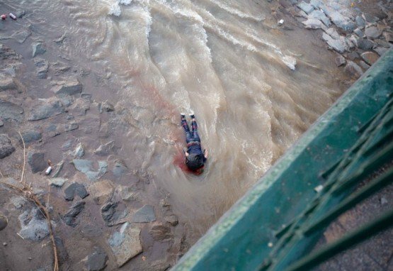 Um manifestante encontra-se &agrave;s margens do rio Mapocho, depois de cair - aparentemente por acidente - durante um protesto contra o governo do presidente chileno Sebastian Pinera em Santiago, em 2 de outubro de 2020.