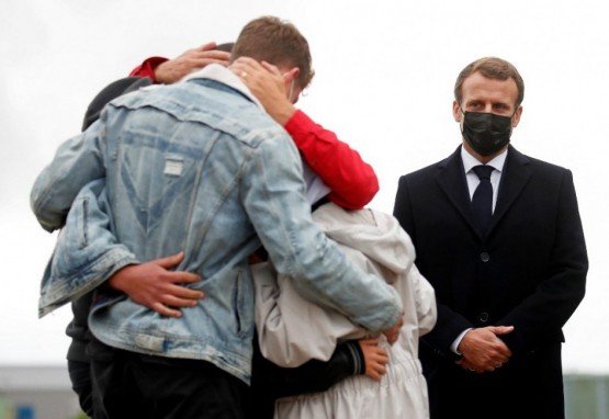 O presidente francês Emmanuel Macron (D) fica ao lado da trabalhadora humanitária francesa Sophie Petronin (C), que é recebida por sua família depois que supostos sequestradores jihadistas libertaram a mulher de 75 anos após quase quatro anos de cativeiro em Mali após sua chegada ao Aeroporto militar Villacoublay perto de Paris em 9 de outubro de 2020. Petronin foi libertada junto com um importante político do Mali e dois reféns italianos no final de 8 de outubro de 2020. A última cidadã francesa conhecida por ter sido mantida refém em qualquer lugar do mundo desde seu sequestro em 2016 , uma Petronin vestida de branco foi abraçada por seu filho quando pousou na capital do Mali, Bamako.