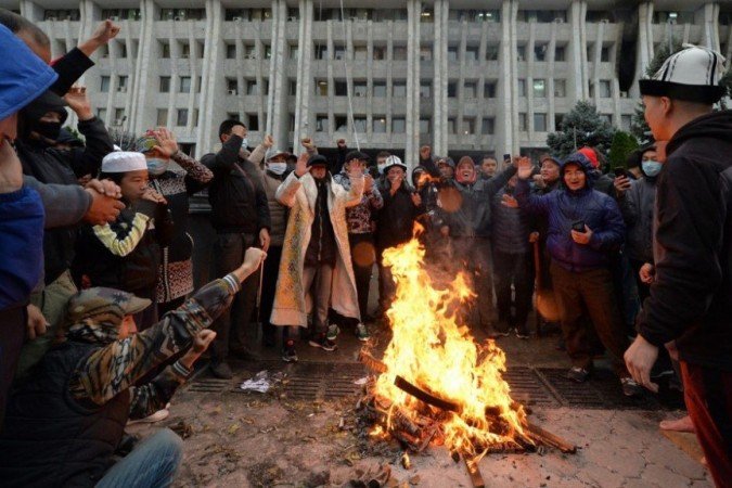 Pessoas protestando contra os resultados de uma votação parlamentar se reúnem em uma fogueira em frente ao prédio principal do governo apreendido, conhecido como Casa Branca, em Bishkek, em 6 de outubro de 2020. - (crédito: VYACHESLAV OSELEDKO / AFP) Pessoas protestando contra os resultados de uma votação parlamentar se reúnem em uma fogueira em frente ao prédio principal do governo apreendido, conhecido como Casa Branca, em Bishkek, em 6 de outubro de 2020. - (crédito: VYACHESLAV OSELEDKO / AFP)