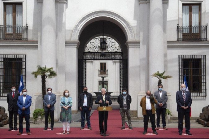 O presidente chileno, Sebastian Pinera, fala ao lado de alguns dos mineiros chilenos resgatados, no palácio presidencial La Moneda, em Santiago, em 13 de outubro de 2020, durante a comemoração do 10º aniversário do resgate dos 33 mineiros do Atacama. -  (crédito: CLAUDIO REYES / AFP)