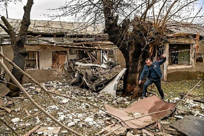 Policial vistoria destroços em quintal, na região azerbaijana de Nagorno-Karabakh 