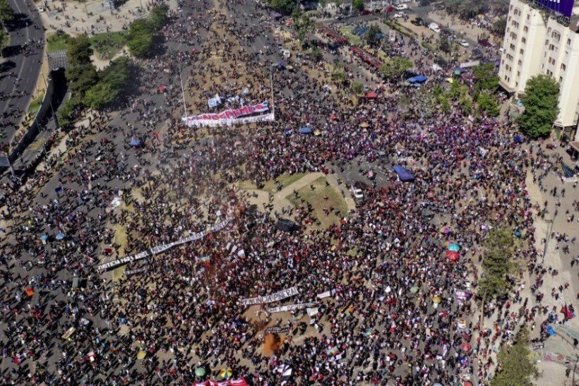 Vista aérea de uma manifestação com uma faixa com os dizeres "Vamos superar" na comemoração do primeiro aniversário da revolta social no Chile, em Santiago, em 18 de outubro de 2020, enquanto o país se prepara para um referendo histórico. Mudar a constituição promulgada pelo ex-ditador Augusto Pinochet, que governou de 1973-90, foi uma das principais reivindicações dos manifestantes durante os dois meses de violenta agitação civil contra o governo e a desigualdade. Os chilenos farão duas perguntas em 25 de outubro: eles querem uma nova constituição e quem deve redigi-la. Vista aérea de uma manifestação com uma faixa com os dizeres "Vamos superar" na comemoração do primeiro aniversário da revolta social no Chile, em Santiago, em 18 de outubro de 2020, enquanto o país se prepara para um referendo histórico. Mudar a constituição promulgada pelo ex-ditador Augusto Pinochet, que governou de 1973-90, foi uma das principais reivindicações dos manifestantes durante os dois meses de violenta agitação civil contra o governo e a desigualdade. Os chilenos farão duas perguntas em 25 de outubro: eles querem uma nova constituição e quem deve redigi-la.