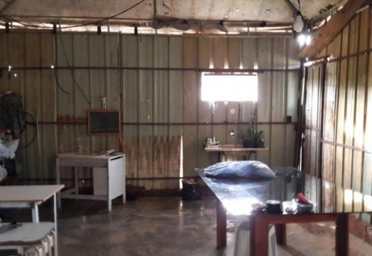 Algumas fam&iacute;lias viviam de maneira improvisada sob um barrac&atilde;o com teto de lona, que tamb&eacute;m funcionava como oficina de costura e dep&oacute;sito de agrot&oacute;xicos