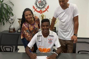 A alegria de Robert Renan ao lado dos pais ao assinar contrato com o Corinthians em 2018 - (crédito: Arquivo pessoal) A alegria de Robert Renan ao lado dos pais ao assinar contrato com o Corinthians em 2018 - (crédito: Arquivo pessoal)