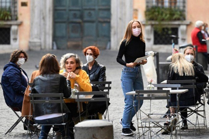 As pessoas se sentam no terraço de um restaurante no centro de Roma, em 25 de outubro de 2020, enquanto o país enfrenta uma segunda onda de infecções para o Covid-19 (o novo coronavírus). - (crédito: Vincenzo PINTO / AFP) As pessoas se sentam no terraço de um restaurante no centro de Roma, em 25 de outubro de 2020, enquanto o país enfrenta uma segunda onda de infecções para o Covid-19 (o novo coronavírus). - (crédito: Vincenzo PINTO / AFP)