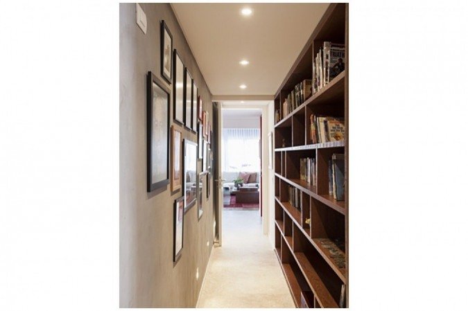 No Residencial André Dias, projeto do Korman Arquitetos, de um lado, fotos e gravuras dispostas em molduras de diferentes tamanhos, deixando o espaço dinâmico; do outro, prateleiras se transformam em uma biblioteca, garantindo a otimização do espaço