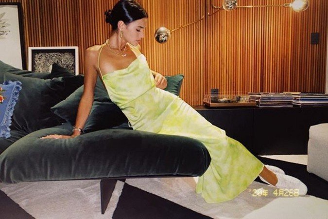 Bruna Marquezine mistura um sleep dress refinado com tênis. Para completar o estilo high low, colares dourados e miçangas coloridas com letras presas em uma corrente fina de ouro