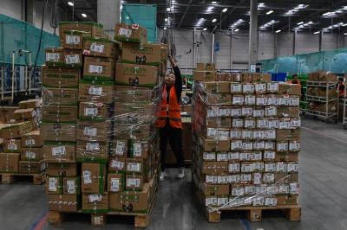 In this picture taken on November 6, 2020, an employee works in the warehouse of Cainiao Smart Logistics Network, the logistics affiliate of e-commerce giant Alibaba, in Wuxi, China's eastern Jiangsu province, ahead of Singles' Day, also known as the Double 11 shopping festival - the world's biggest shopping event - which falls on November 11. / AFP / Hector RETAMAL - (crédito: HECTOR RETAMAL) In this picture taken on November 6, 2020, an employee works in the warehouse of Cainiao Smart Logistics Network, the logistics affiliate of e-commerce giant Alibaba, in Wuxi, China's eastern Jiangsu province, ahead of Singles' Day, also known as the Double 11 shopping festival - the world's biggest shopping event - which falls on November 11. / AFP / Hector RETAMAL - (crédito: HECTOR RETAMAL)
