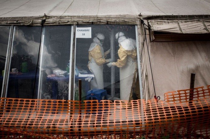 Foto tirada em 09 de março de 2019. Trabalhadores da saúde são vistos dentro da 'zona vermelha' de um centro de tratamento de ebola. -  (crédito: AFP / JOHN WESSELS)