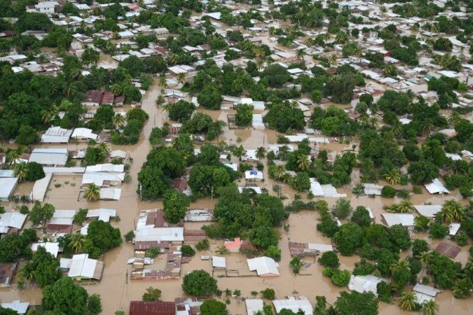 Vista aérea do município de La Lima, nos arredores de San Pedro Sula, 240 km ao norte de Tegucigalpa, inundado devido ao transbordamento do rio Chamelecon após a passagem do furacão Iota, ocorrido em 18 de novembro de 2020. - (crédito: Orlando SIERRA / AFP) Vista aérea do município de La Lima, nos arredores de San Pedro Sula, 240 km ao norte de Tegucigalpa, inundado devido ao transbordamento do rio Chamelecon após a passagem do furacão Iota, ocorrido em 18 de novembro de 2020. - (crédito: Orlando SIERRA / AFP)