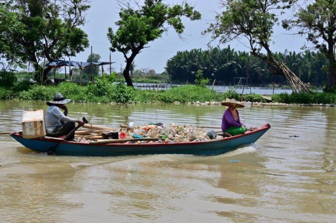 Esta foto tirada em 20 de outubro de 2020 mostra idosos recolhendo copos plásticos reciclados em um barco perto de Teluk Naga, Tangerang, província de Banten. Os cientistas estão recorrendo à tecnologia de satélite para rastrear essa montanha de resíduos e descobrir como o segundo maior contribuinte de resíduos marinhos do mundo - perdendo apenas para a China - pode resolver a bagunça.