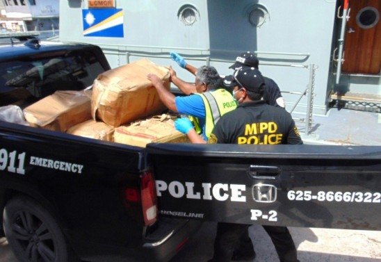 Polícia das Ilhas Marshall carrega uma caixa cheia de "tijolos" de cocaína para confisco e destruição. 