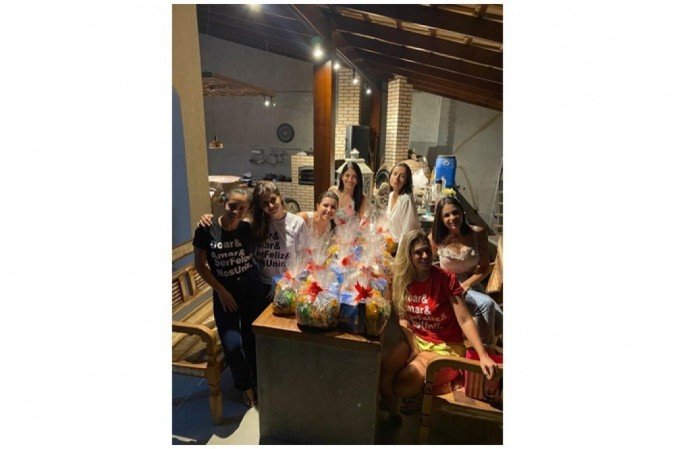 Ana Cristina Ferreira de Souza (E) e parte do grupo de voluntários preparando os kits natalinos (detalhe) que serão distribuídos  