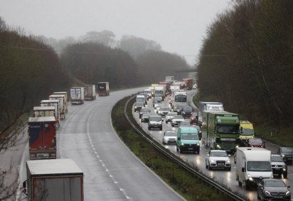 Carros de polícia patrulham enquanto caminhões de carga e veículos de mercadorias fazem fila em um trecho fechado da autoestrada M20 que leva ao Porto de Dover, perto de Ashford, em Kent, sudeste da Inglaterra em 22 de dezembro de 2020, depois que uma série de países proibiu viagens, incluindo frete acompanhado chegando do Reino Unido, devido à rápida disseminação de uma nova cepa de coronavírus mais infecciosa. O porto crítico da costa sul da Grã-Bretanha em Dover disse em 20 de dezembro que estava fechando para todas as cargas e passageiros acompanhados devido às restrições da fronteira francesa 