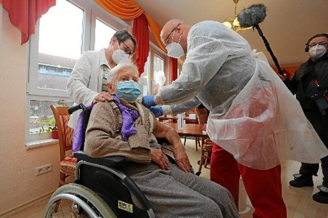 O médico Bernhard Ellendt (D) aplica imunizante da Pfizer/BioNTech em Edith Kwoizalla, 101 anos, em asilo de Halberstadt: primeira alemã protegida