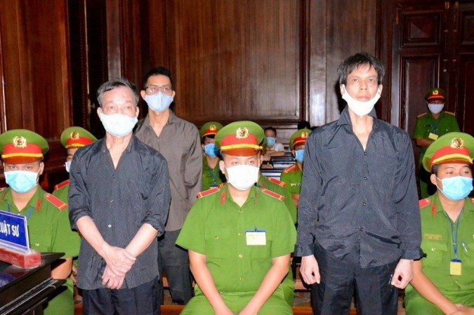 Esta foto tirada e divulgada pela Agência de Notícias do Vietnã em 5 de janeiro de 2021 mostra os blogueiros vietnamitas Pham Chi Dung (D), Nguyen Tuong Thuy (E) e Le Huu Minh Tuan (3o E) durante seu julgamento no tribunal de Ho Chi Minh cidade. - (crédito: STR / Agência de Notícias do Vietnã / AFP) Esta foto tirada e divulgada pela Agência de Notícias do Vietnã em 5 de janeiro de 2021 mostra os blogueiros vietnamitas Pham Chi Dung (D), Nguyen Tuong Thuy (E) e Le Huu Minh Tuan (3o E) durante seu julgamento no tribunal de Ho Chi Minh cidade. - (crédito: STR / Agência de Notícias do Vietnã / AFP)