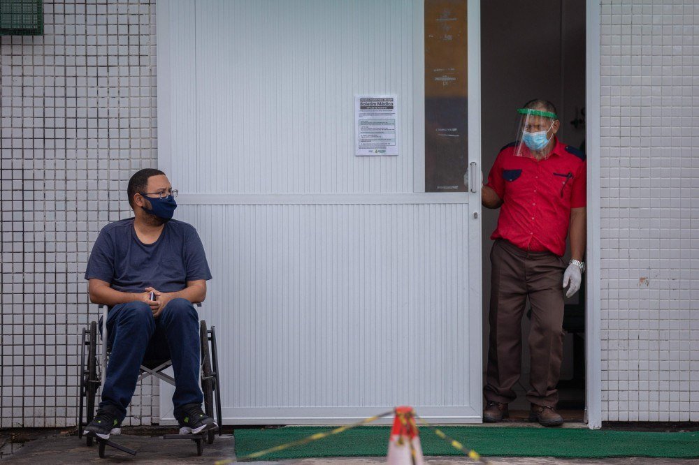 Trabalhadores da saúde usam roupas protetoras ao deixarem o corpo de uma vítima do novo coronavírus em um contêiner refrigerado do Hospital Público Vinte Oito de Agosto, unidade de tratamento de pacientes do COVID-19 em Manaus, Estado do Amazonas, Brasil, em 4 de janeiro de 2021