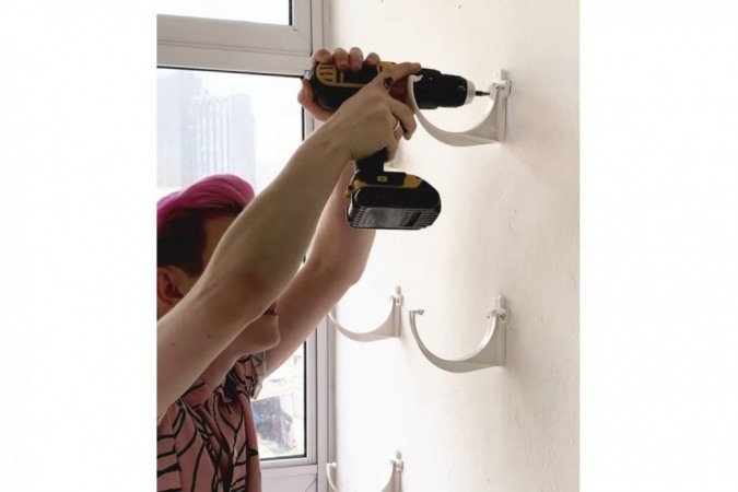 Passo 2: Com a furadeira, fure nas marcações e coloque as buchas.Em seguida, parafuse os suportes das calhas.
Para evitar infiltrações, antes de colocar as buchas, Matheus recomenda selar os buracos na parede com bisnagas de silicone.
A calha fica alguns centímetros afastada das paredes. O cuidado extra pode evitar problemas no futuro.