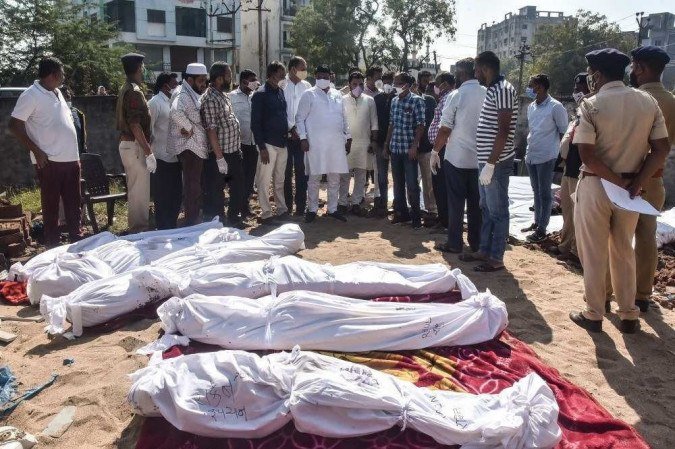 Policiais e residentes se reúnem ao redor dos corpos das vítimas depois que um caminhão perdeu o controle e as atropelou enquanto dormiam no distrito de Surat, a 270 km de Ahmedabad em 19 de janeiro de 2021. -  (crédito: AFP)