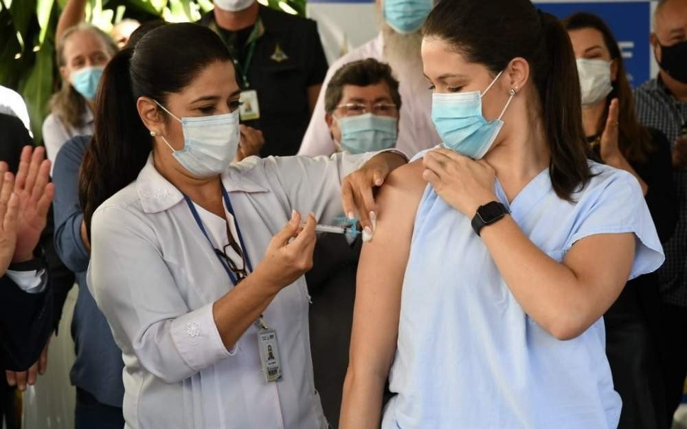 Lídia Rodrigues Dantas, 31, recebendo a primeira dose da vacina contra a covid-19 
