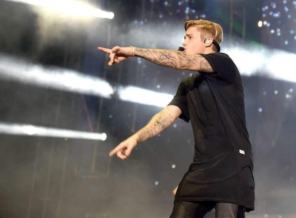 O cantor Justin Bieber também utiliza os t-shirts dress no dia a dia e, principalmente, em shows. Ele dá preferência a tons mais escuros e uma camiseta de botão xadrez aberta
