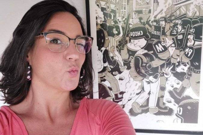 A escritora, jornalista e produtora cultural brasiliense Janaína Michalski, com quadro de Caio Gomez ao fundo -  (crédito: Autorretrato/divulgação)