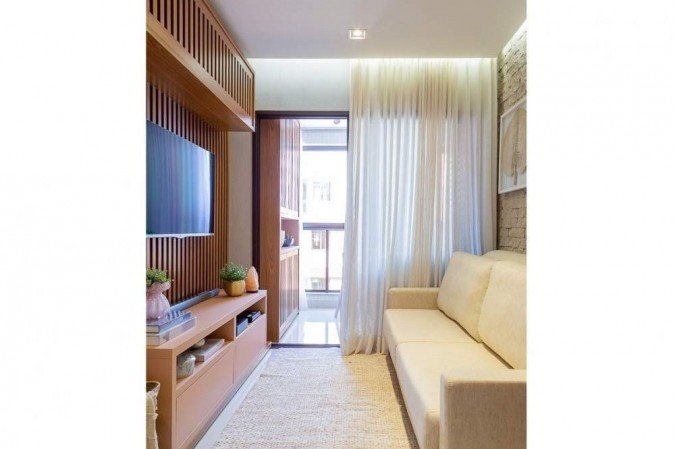 Armários se estendem para a varanda, dando uma ideia de integração: linhas verticais nos armários passam a sensação de amplitude