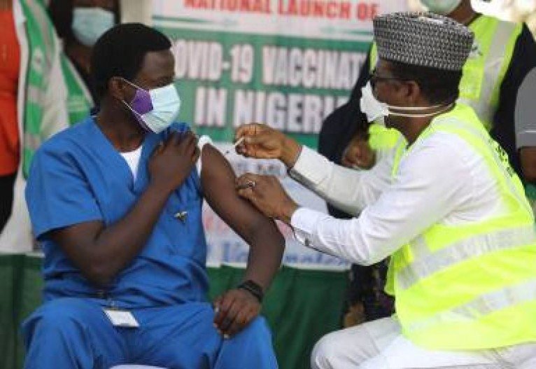 Dr. Ngong Cyprian (L), the first Nigerian to receive the first dose of the Oxford/AstraZeneca vaccine at the National Hospital Abuja, Nigeria on March 5, 2021. The Nigerian Government begins its roll-out of nearly 4 million of the Oxford/AstraZeneca vaccine in Nigeria  / AFP / Kola Sulaimon