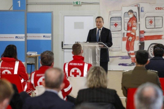 O primeiro-ministro italiano, Mario Draghi, faz um discurso durante uma visita a um novo centro de vacinação no Aeroporto Fiumicino, perto de Roma, em 12 de março de 2021, em meio à pandemia covid-19. -  (crédito: GUGLIELMO MANGIAPANE / POOL / AFP)