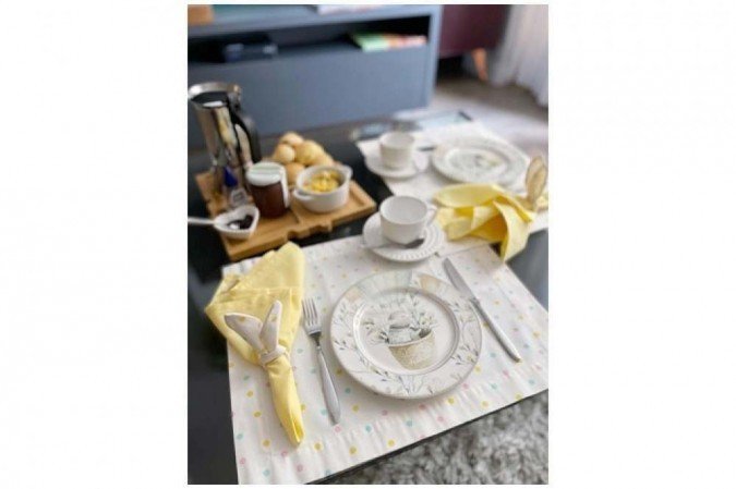 Pratos de coelho da loja on-line Casa de Mineira, jogo americano de poá colorido, argola de orelhas de coelho e uma mesa de café da manhã para a Páscoa preparada por Gabriela Paganini