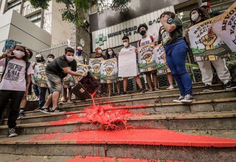 Em São Paulo (SP), manifestantes derramaram tinta vermelha em frente ao prédio do Ministério da Saúde para simbolizar o sangue das vítimas da covid-19

